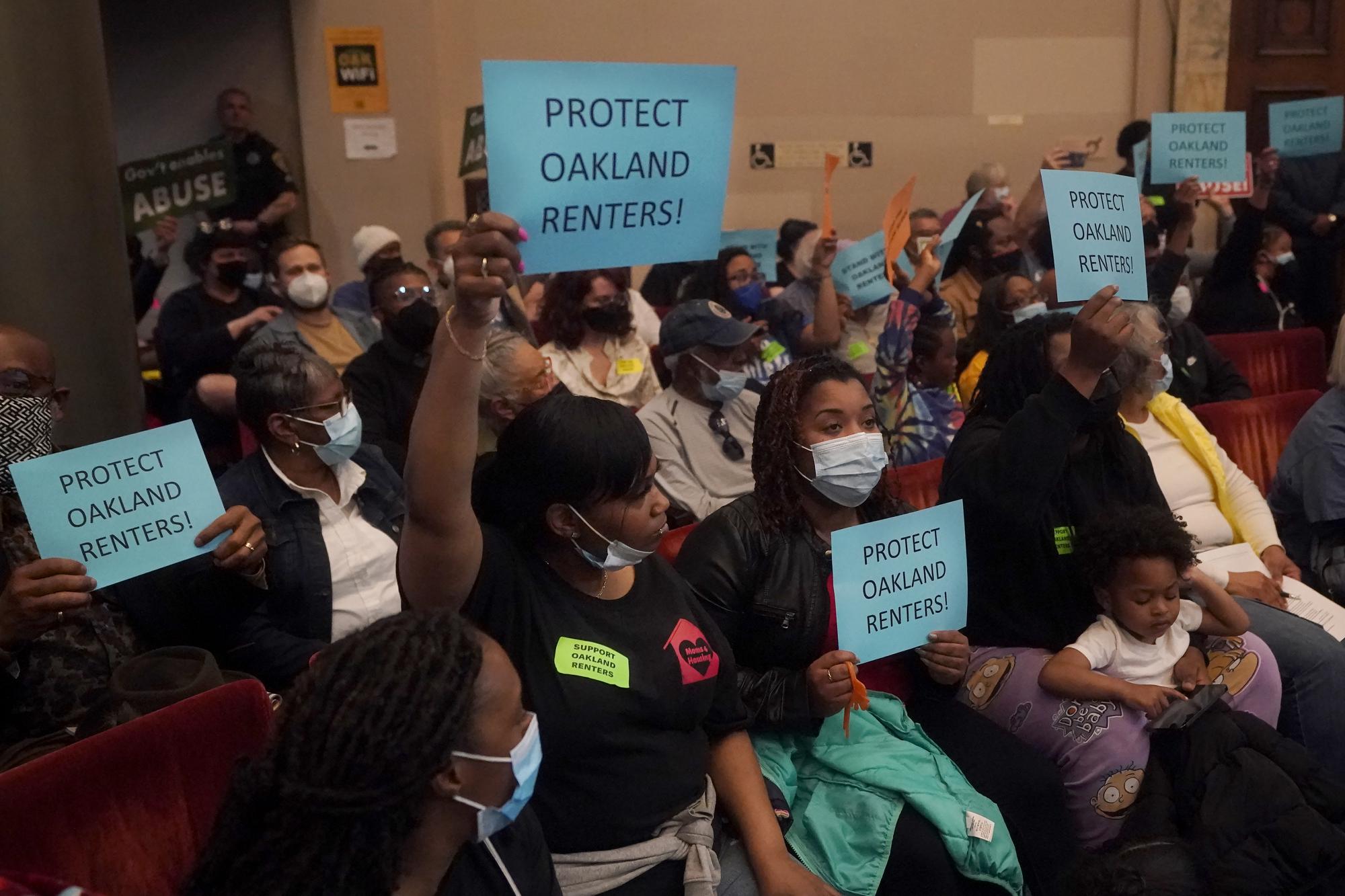 People supporting renters and a ramp down of the eviction moratorium hold up signs during a Oakland City Council special community and economic development committee at City Hall in Oakland, Calif., Tuesday, April 11, 2023. Eviction moratoriums were set in place across the U.S. at the start of the pandemic and most have expired, but not in the Bay Area cities of Oakland, San Francisco and Berkeley, where housing and rates of homelessness are both high. Housing advocates say low-income tenants still need protections. Oakland's eviction ban lifts July 15. (AP Photo/Jeff Chiu)