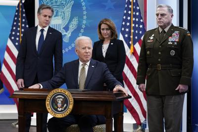 El presidente Joe Biden hace una pausa después de firmar una delegación de autoridad en el Auditorio de south Court en el campus de la Casa Blanca en Washington, el miércoles 16 de marzo de 2022. Desde la izquierda, el secretario de Estado Antony Blinken, Biden, la subsecretaria de Defensa Kathleen Hicks y el presidente del Estado Mayor Conjunto, el general Mark Milley. (AP Photo/Patrick Semansky)