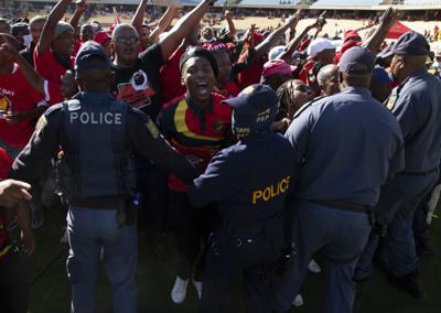 Mineros descontentos chocan con la policía en una manifestación por el Día del Trabajador en Rustenburg, Sudáfrica, el domingo 1 de mayo de 2022. (Foto AP/Denis Farrell)