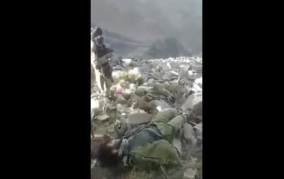 En esta escena extraída de un video, probablemente tomada por el Talibán, compartida en internet y proporcionada por Testigo Afgano, una organización sin fines de lucro con base en Gran Bretaña, un combatiente talibán se ve de pie entre cadáveres en el suelo en el distrito de Dara, provincia de Panjshir, Afganistán, el 14 de septiembre de 2022. (Testigo Afgano via AP)