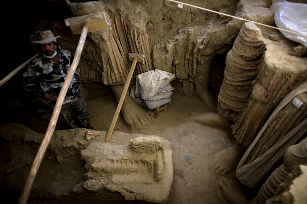 ARCHIVO - En esta fotografía tomada el martes 12 de octubre de 2010 en el valle de Mes Aynak, al sur de Kabul, Afganistán, un arqueólogo afgano se encuentra junto a los restos de las estatuas de Buda descubiertas dentro de un antiguo templo.  El valle es el segundo cobre sin explotar más grande del mundo, con un valor estimado de casi $ 1 billón.  (Foto AP/Dusan Vranic, archivo)