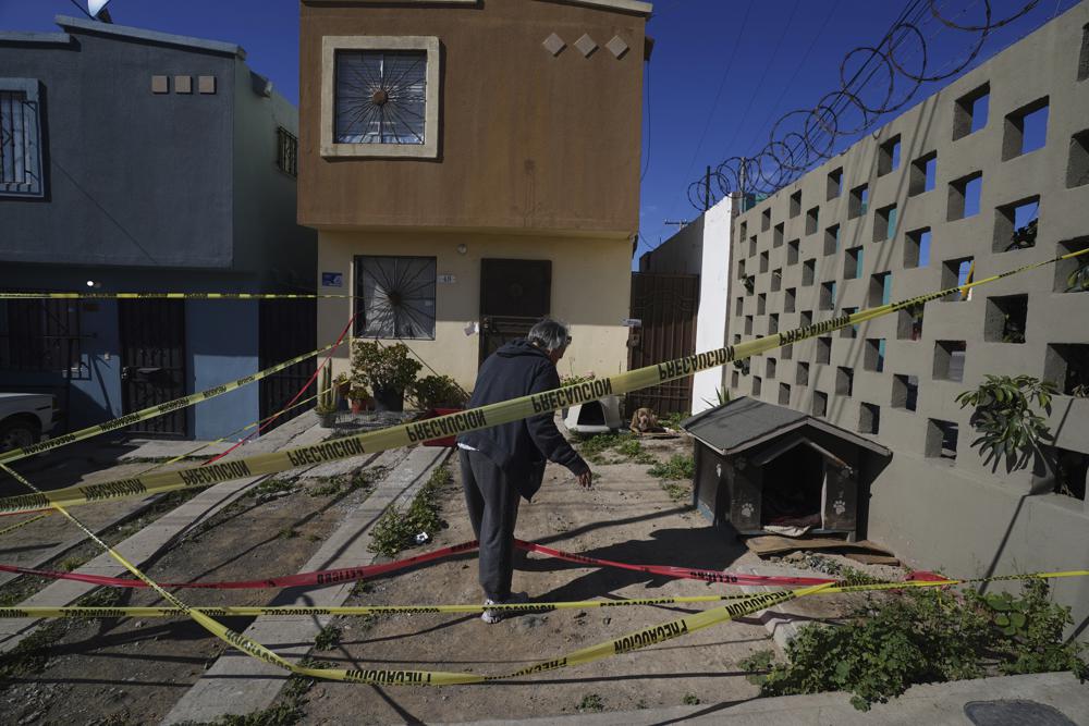 Xochitl Zamora, amiga de la periodista asesinada Lourdes Maldonado, recoge las mascotas de su amiga de la escena del crimen y de la casa de Maldonado, en Tijuana, México, el martes 25 de enero de 2022. (AP Foto/Marco Ugarte)