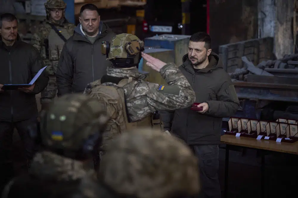 In this photo provided by the Ukrainian Presidential Press Office, Ukrainian President Volodymyr Zelenskyy, right, awards a serviceman at the site of the heaviest battles with the Russian invaders in Bakhmut, Ukraine, Tuesday, Dec. 20, 2022. (Ukrainian Presidential Press Office via AP)
