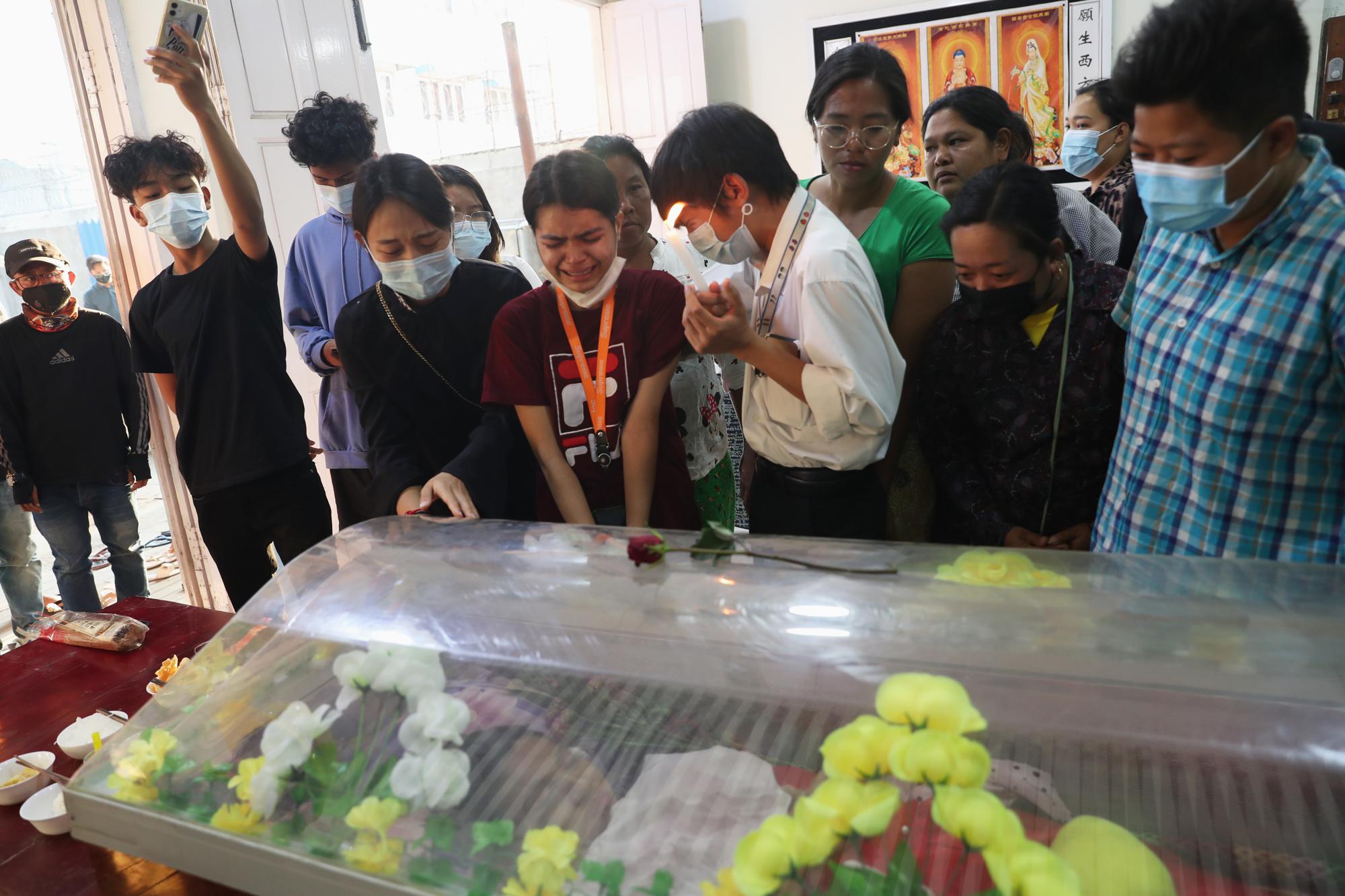 FILE - In this Wednesday, Mar. 3, 2021 file photo, people mourn over the body of 19-year-old Kyal Sin, also known as Angel, a university student who was shot in the head during an anti-military takeover rally in Mandalay, Myanmar. Authorities released a death certificate saying the bullet that killed her didn’t match the caliber used by police, that it came from the wrong direction for security forces to be responsible, and blamed protesters for her death. However, local news reports and social media accounts said security forces were firing live rounds. (AP Photo)