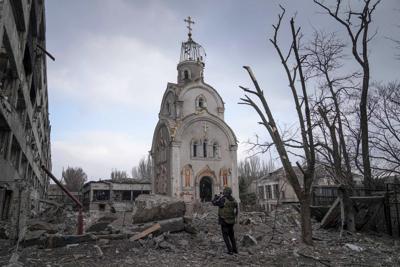 ARCHIVO - Un soldado ucraniano toma una fotografía de una iglesia dañada por un bombardeo en un distrito residencial de Mariúpol, Ucrania, el 10 de marzo de 2022. (AP Foto/Evgeniy Maloletka, archivo)