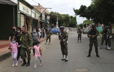 Un soldado camina con su familia cerca de la base militar donde explotó un coche bomba en Cúcuta, Colombia, el martes 15 de junio de 2021. (AP Foto/Ferley Ospina)