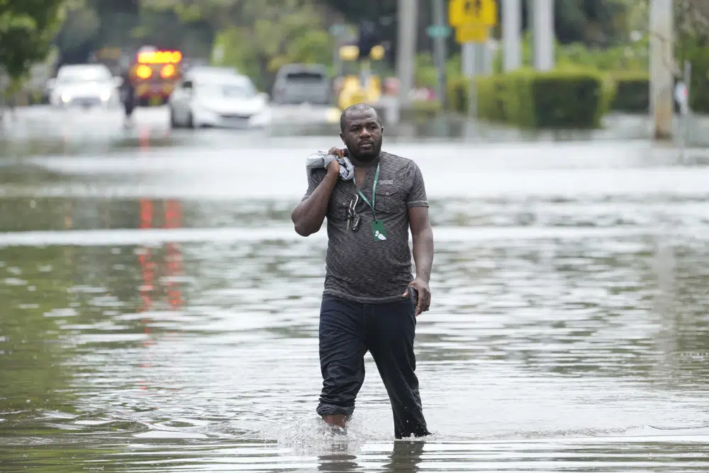 FILE - A man walks out of a flooded neighborhood Thursday, April 13, 2023, in Fort Lauderdale, Fla. Florida Gov. Ron DeSantis Saturday, April 22, 2023, is asking the Biden administration to declare Broward County a disaster area due to flooding earlier this month after record rainfall. (AP Photo/Marta Lavandier, File)