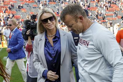 Kes Harsin, izquierda, habla con su esposo el entrenador en jefe de Auburn, Bryan Harsin, mientras sale del campo después de un partido de fútbol universitario de la NCAA contra Arkansas, el sábado 29 de octubre de 2022, en Auburn, Alabama. (AP Photo / Butch Dill)