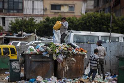 Niños buscan algo de valor en la basura junto a un mercado en Beirut, Líbano, el lunes 12 de abril de 2021. (AP Foto/Hassan Ammar, Archivo)