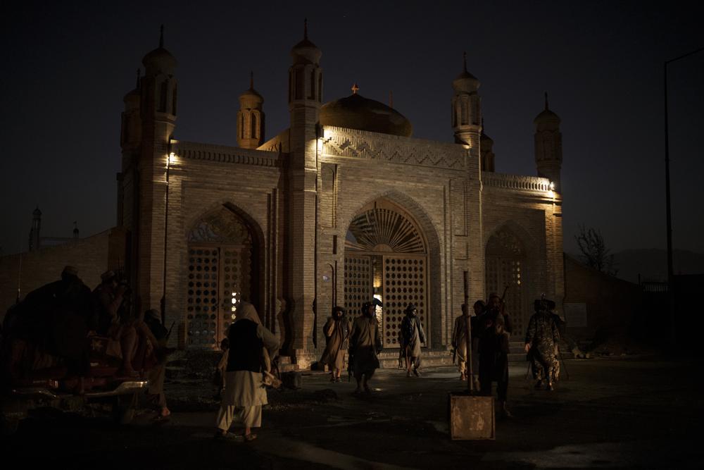 Taliban fighters walk at the entrance of the Eidgah Mosque after an explosion in Kabul, Afghanistan, Sunday, Oct. 3, 2021. A bomb exploded in the entrance of the mosque in the Afghan capital on Sunday leaving a "number of civilians dead," a Taliban spokesman said. (AP Photo/Felipe Dana)