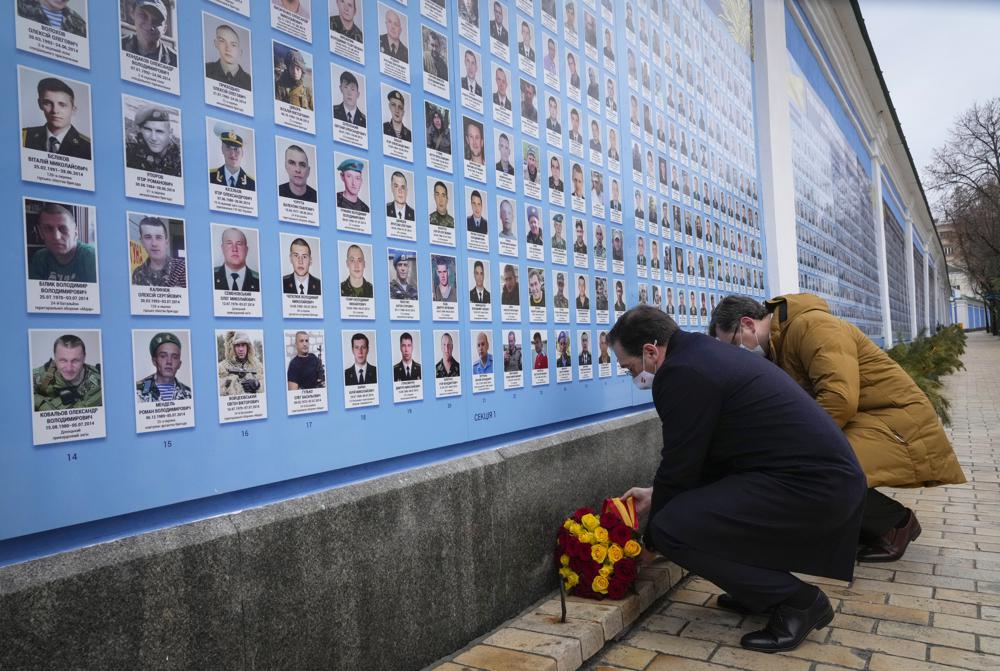 El ministro de Relaciones Exteriores de Ucrania, Dmytro Kuleba, a la derecha, y el ministro de Relaciones Exteriores de España, José Manuel Albares, depositan flores en el Muro Conmemorativo de los Defensores de Ucrania Caídos en la Guerra Ruso-Ucraniana en Kiev, Ucrania, el miércoles 9 de febrero de 2022. (Foto AP/Efrem Lukatsky )