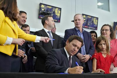 El gobernador de Florida, Ron DeSantis, firma un proyecto de ley durante una conferencia de prensa el jueves 18 de noviembre de 2021, en Brandon, Florida. (AP Foto/Chris O'Meara)