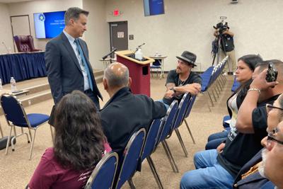 El senador estatal de Texas Roland Gutierrez, de pie, habla con familiares de niños muertos en la masacre escolar en Uvalde, antes de una reunión en Austin de la comisión estatal sobre ley y orden el 27 de octubre del 2022.  (AP Foto/Acacia Coronado)