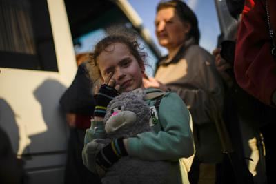 Una niña y su familia que huyeron de Mariúpol llegan a un centro de recepción de personas desplazadas en Zaporiyia, Ucrania, el domingo 8 de mayo de 2022. (AP Foto/Francisco Seco)