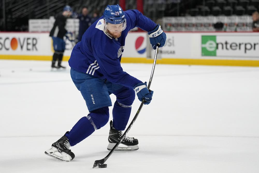 Colorado Avalanche center Nathan MacKinnon (29) hits a shot during an NHL hockey practice, ahead of Game 2 of the Stanley Cup Finals, Friday, June 17, 2022, in Denver. (AP Photo/John Locher)