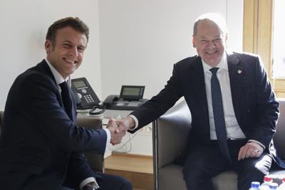 El presidente francés Emmanuel Macron, izquierda, y el canciller alemán Olaf Scholz sonríen en una reunión bilateral al margen de una cumbre de la Unión Europea, el jueves 20 de octubre de 2022, en Bruselas. (Olivier Hoslet, foto compartida vía AP)