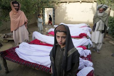 Varias personas esperan junto a los cadáveres de personas fallecidas en un sismo, en la localidad de Gayan, en la provincia de Paktiká, Afganistán, el 23 de junio de 2022. (AP Foto/Ebrahim Nooroozi)