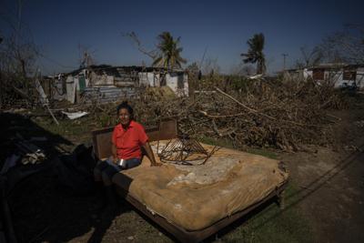 Mari Carmen Zambrano posa en su cama rota y mojada mientras la seca afuera de su casa que perdió el techo por el huracán Ian en La Coloma, en la provincia de Pinar del Río, Cuba, el miércoles 5 de octubre de 2022. (AP Foto/Ramón Espinosa)