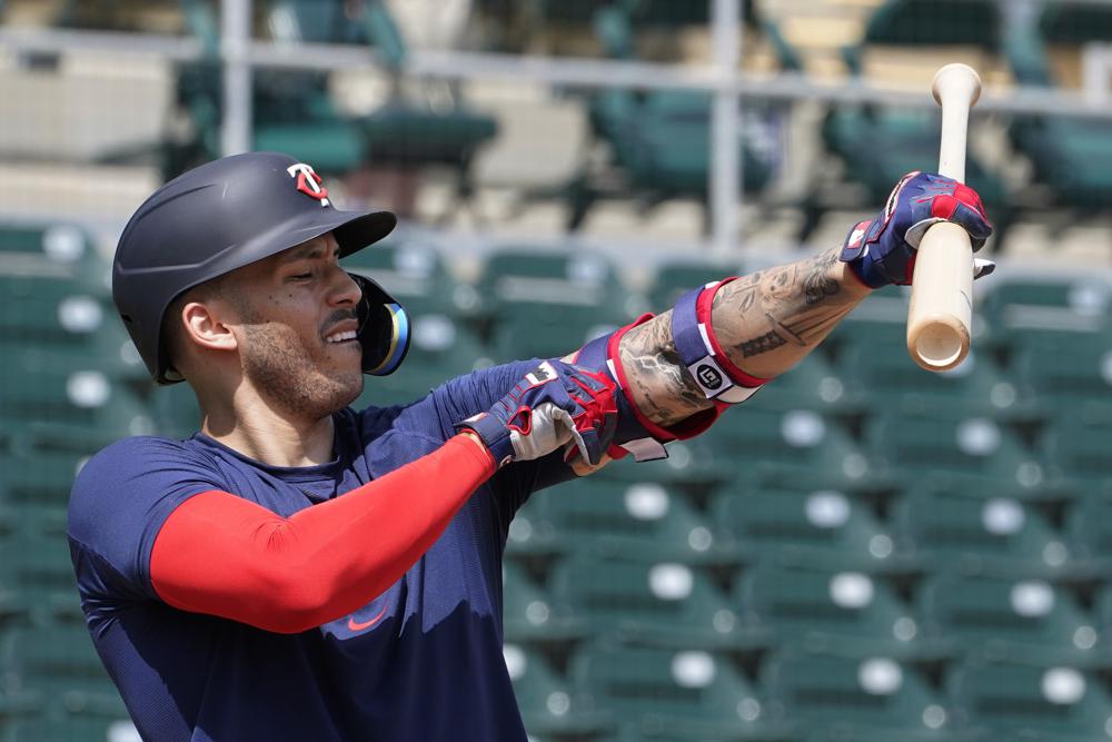 Carlos Correa de los Mellizos de Minnesota ajusta su protector de brazo durante una práctica de bateo, el miércoles 23 de marzo de 2022, en Fort Myers, Florida. (AP Foto/Steve Helber)