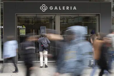 Personas caminan frente a la entrada de la Galeria Kaufhof, en la calle comercial Zeil de Fráncfort, Alemania, el lunes 13 de marzo de 2023. (Sebastian Gollnow/dpa vía AP)