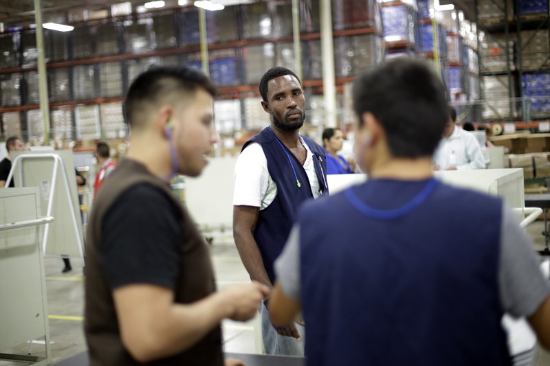 Haitian employee of CCL Industries, Photo: Gregory Bull/AP