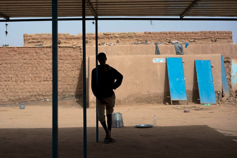 A migrant who was expelled from Algeria stands in a transit center in Arlit, Niger on Thursday, May, 31, 2018. The International Organization for Migration normally organizes transport home for the men, women and children who have been expelled from Algeria. But with no name, confirmed nationality or family to claim him, the anonymous man was trapped in the compound. (AP Photo/Jerome Delay)