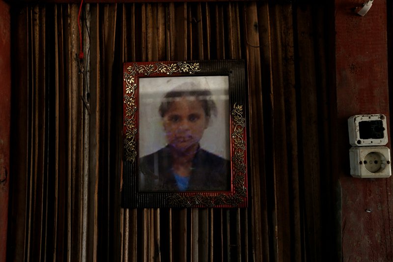In this Oct. 21, 2018, photo, a framed photo of Adelina Sau hangs on the wall of her family's home in Abi village in West Timor, Indonesia. Adelina had been working as a maid for a Malaysian family when a local lawmaker's office received a tip from neighbors who suspected she was being abused. Following her death, an autopsy determined she died of septicemia and cited possible abuse and neglect. (AP Photo/Tatan Syuflana)