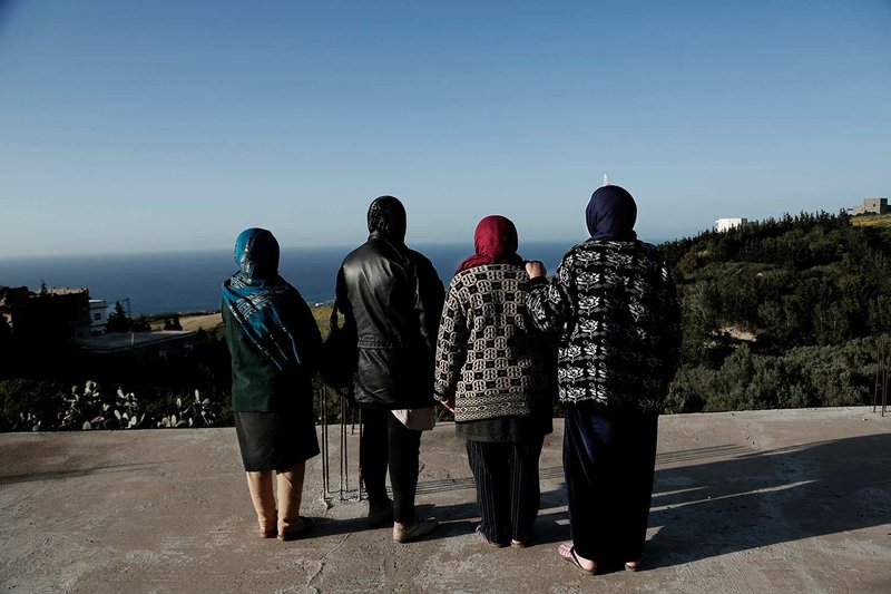 In this April 12, 2018 photo, women whose sons went missing look at the shoreline in the town of Ras Jabal, Bizerte, Tunisia. An Associated Press tally has documented at least 56,800 migrants dead or missing worldwide from 2014 to 2018 _ almost double the number found in the world’s only official attempt to count them, by the U.N.’s International Organization for Migration. (AP Photo/Nariman El-Mofty)