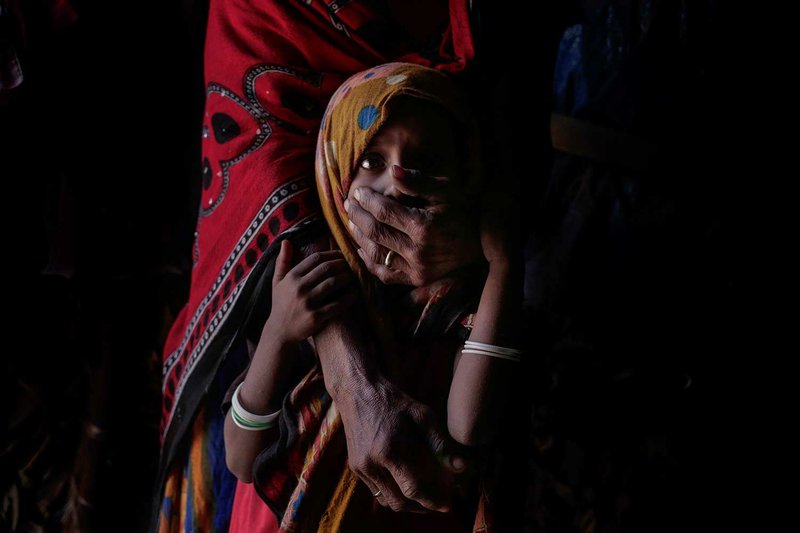 In this Feb. 9, 2018 photo, Hagar Yahia holds her daughter Awsaf, a thin 5-year-old who is getting no more than 800 calories a day from bread and tea, half the normal amount for a girl her age, in Abyan, Yemen. Yahia, a mother of eight breaks down in tears talking about her family's deprivation. Late last year, as fighting closed in on Hayis, they fled more than 200 miles, eventually ending up in the village of Red Star on the Arabian Sea coast in the south. Ever since, they've struggled to find enough food. (AP Photo/Nariman El-Mofty)