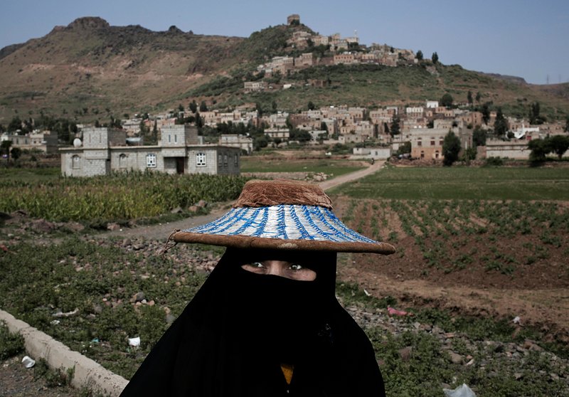 In this Aug. 3, 2018 photo, a woman walks through Ibb, Yemen. Travelling across Yemen, an Associated Press team found "in-between" moments everywhere _ Yemenis fitting their normal lives in between the destruction wreaked by four years of civil war. (AP Photo/Nariman El-Mofty)
