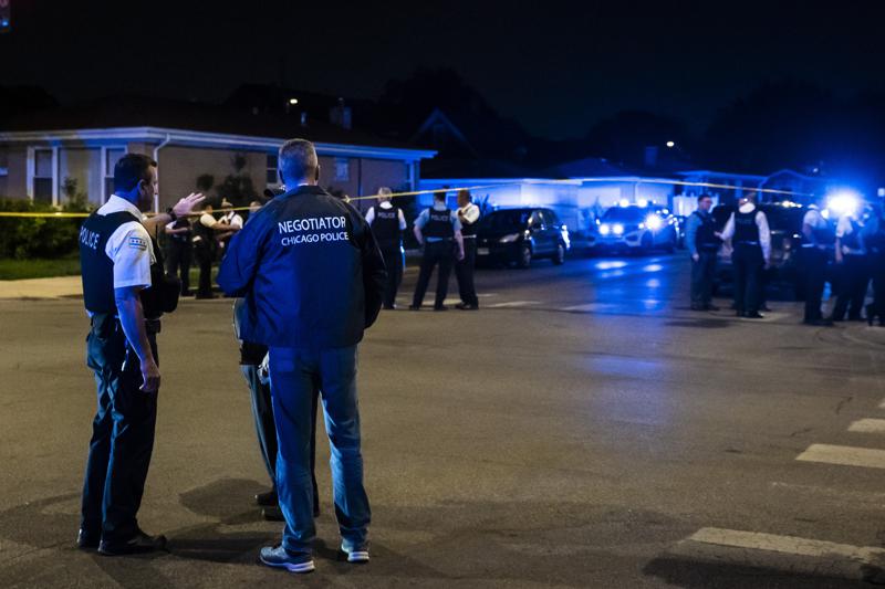 Chicago police and SWAT officers investigate in the 4400 block of West Walton Street where an alleged gunman barricaded himself in a building after one man was killed and three other people were wounded in a shooting in West Humboldt Park on the West Side, Sunday night, May 29, 2022. False claims that guns are illegal in Chicago have circulated widely on social media. (Ashlee Rezin/Chicago Sun-Times via AP)