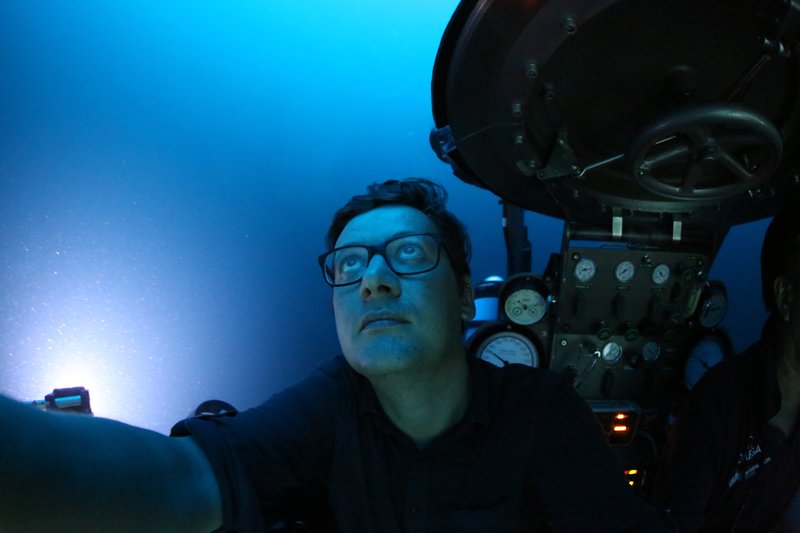 AP reporter, David Keyton, looks out of a submersible at around 400 feet below the surface off the coast of the island of St. Joseph in the Seychelles, April 8, 2019. (AP Photo/David Keyton)