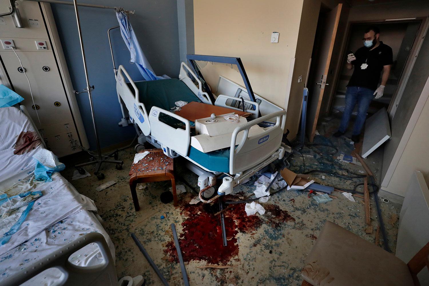 FILE - In this Wednesday, Aug. 5, 2020 file photo, shows Michel Rahi stands inside a room at the Saint George Hospital University Medical Center that was damaged by the Aug. 4 massive blast at Beirut's seaport, in Beirut, Lebanon. The hospital, one of Lebanon’s most prestigious and oldest medical centers, is located about 900 meters (yards) from a warehouse in Beirut port, where hundreds of tons of ammonium nitrate, a highly explosive fertilizer, blew up a year ago, triggering one of the largest non-nuclear explosions in history. (AP Photo/Hassan Ammar, File)