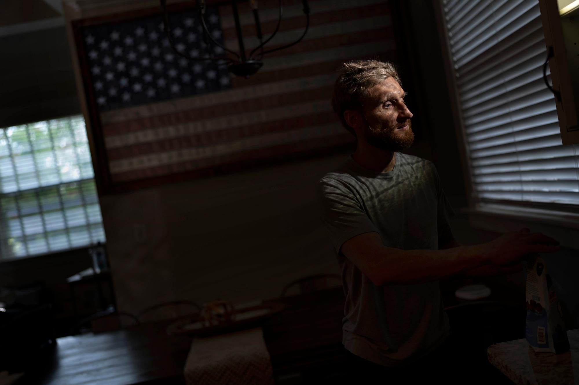Brad Snyder, a Navy explosives expert who was blinded in a mine explosion in Afghanistan in 2011, prepares tea for his wife in their Princeton, N.J., home on Aug. 4, 2021. Snyder won the gold medal in the Triathlon PTV1 at the Paralympics in Tokyo on Aug. 27, 2021. (AP Photo/Emilio Morenatti)