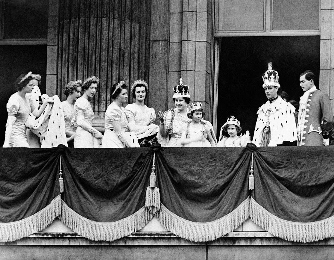 Britain's King George VI and Queen Elizabeth, with their daughters, Princess Elizabeth and Princess Maragret in their Coronation robes, as they appeared on the balcony of Buckingham Palace, in London, on May 12, 1937, after their return from the Coronation at Westminster Abbey. Others are ladies in waiting. (AP Photo)