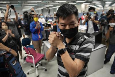 Fotografía de archivo del 23 de junio de 2021 de Lam Man-chung, centro, director en jefe del Apple Daily, en la sede del medio antes de que dejara de publicar en Hong Kong. (AP Foto/Kin Cheung, Archivo)