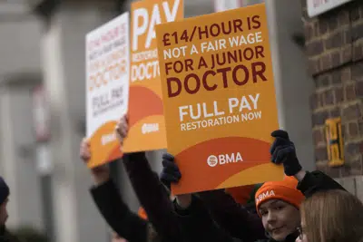 ARCHIVO - Médicos de inicio de carrera muestran pancartas mientras realizan un paro de labores afuera del Hospital Santa María, en Londres, el martes 14 de marzo de 2023. (AP Foto/Alastair Grant, archivo)