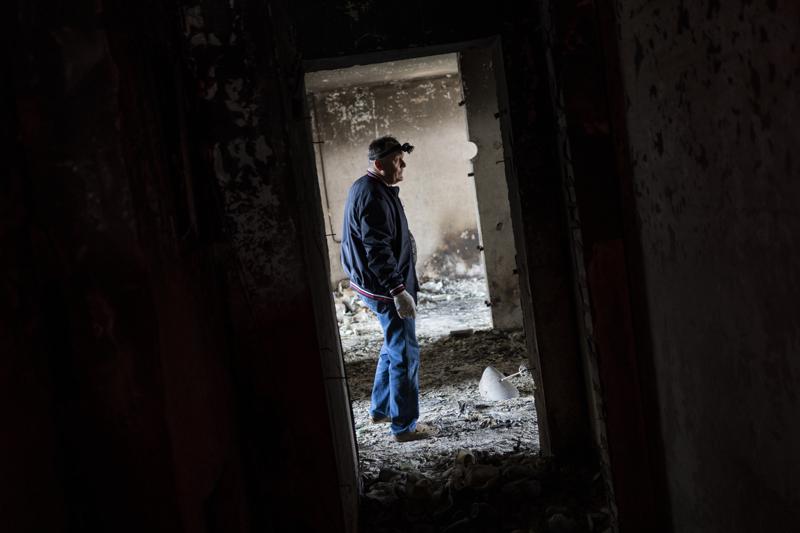 Serhii Klochko, 54, inspects his neighbour's apartment that was damaged during shelling in Kharkiv, eastern Ukraine, Saturday, May 21, 2022. (AP Photo/Bernat Armangue)