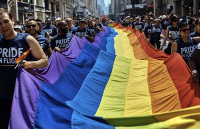 ARCHIVO - En el desfile LGBTQ llevan la bandera del movimiento por la Quinta Avenida de Nueva York el 24 de junio del 2018. Desfiles de celebración del orgullo LGBTQ se realizaban en algunas de las mayores ciudades de Estados Unidos el 26 de junio del 2022, en medio de renovados temores sobre el potencial para la erosión de libertades conseguidas con décadas de activismo. (AP Foto/Andres Kudacki)