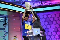 Dev Shah, 14, from Largo, Fla., lifts the trophy next to Scripps CEO Adam Symson after he won the Scripps National Spelling Bee finals, Thursday, June 1, 2023, in Oxon Hill, Md. (AP Photo/Nick Wass)