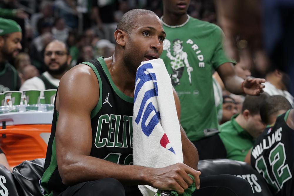 Boston Celtics center Al Horford wipes his face while seated on the bench as the Celtics trail the Milwaukee Bucks in the second half of Game 1 in the second round of the NBA Eastern Conference playoff series, Sunday, May 1, 2022, in Boston. (AP Photo/Steven Senne)