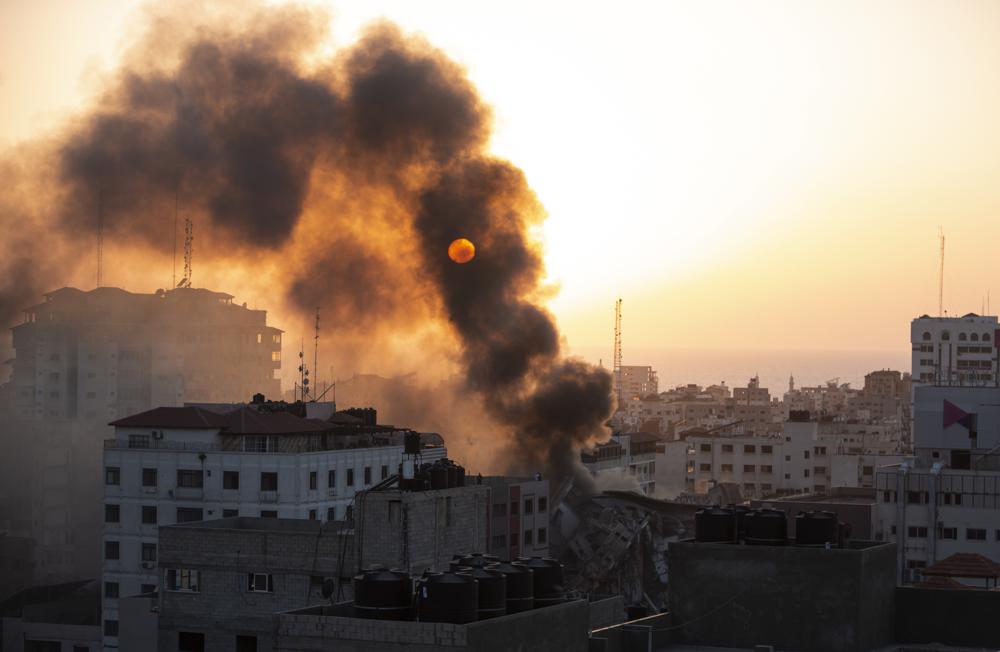 Smoke is seen from a collapsed building after it was hit by Israeli airstrikes on Gaza City, Wednesday, May 12, 2021. The Israeli airstrike was the latest in a series of assaults on targets in the Gaza Strip after a long dispute between Israel and Hamas erupted into an exchange of rocket attacks from Gaza and Israeli retaliation. (AP Photo/Khalil Hamra)