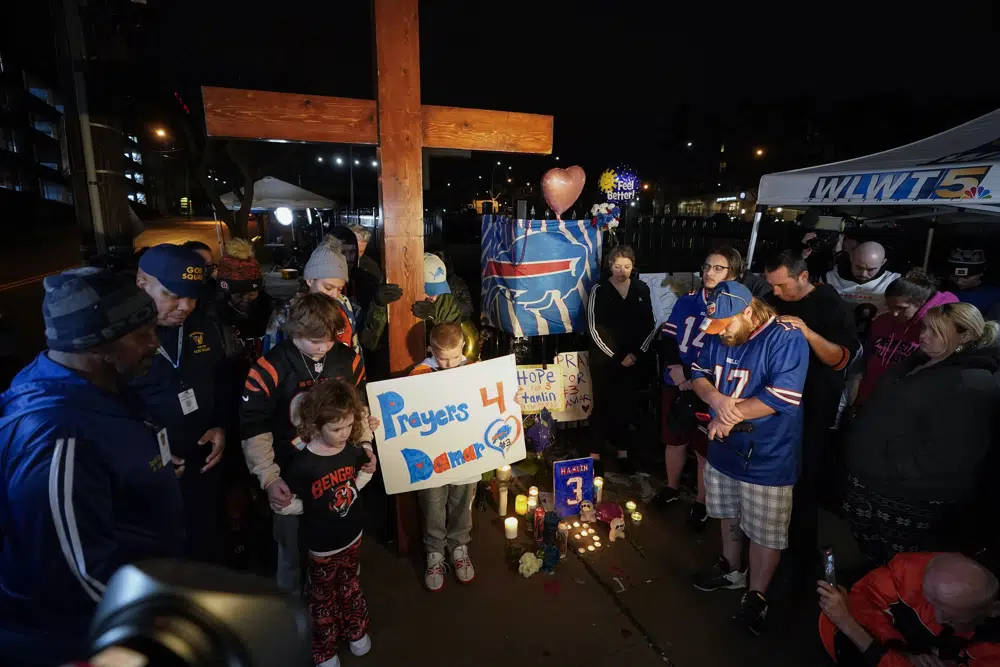 FILE - People pray during a prayer vigil for Buffalo Bills' Damar Hamlin outside of University of Cincinnati Medical Center, Tuesday, Jan. 3, 2023, in Cincinnati. (AP Photo/Darron Cummings, File)