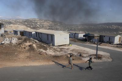 Chicos palestinos corren por el puesto de avanzada israelí Eviatar, cerca de la localidad de Naplusa, en el norte de Cisjordania, el lunes 21 de junio de 2021. (AP Foto/Sebastian Scheiner)