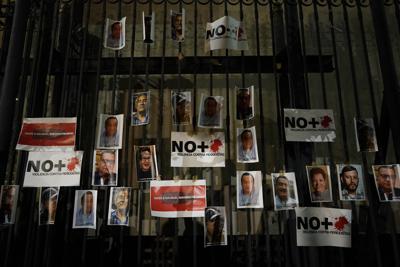 Fotos de periodistas asesinados se publican en la puerta de la oficina del Fiscal General de México durante una vigilia para protestar por el asesinato del periodista Heber López, en la Ciudad de México, el lunes 14 de febrero de 2022. López, quien era el director del sitio de noticias en línea Noticias Web, fue asesinado a tiros el jueves 10 de febrero en la ciudad costera de Salina Cruz, en el estado de Oaxaca. El Comité para la Protección de los Periodistas (CPJ, por sus siglas en inglés) declaró estas seis semanas pasadas como las "más mortíferas para la prensa mexicana en más de una década". (AP Foto/Eduardo Verdugo)