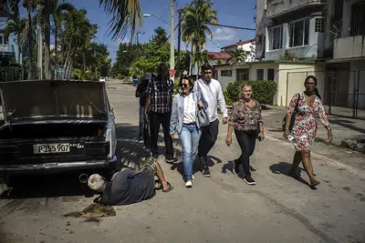 Los candidatos al Congreso, Denisse Ricardo, centro izquierda, y Carlos Miguel Pérez, centro, hacen campaña en La Habana, Cuba, el martes 21 de marzo de 2023. Unos ocho millones de cubanos votarán el domingo 26 de marzo por los diputados que integrarán la Asamblea Nacional del Poder Popular, de una cámara. (Foto AP/Ramón Espinosa)