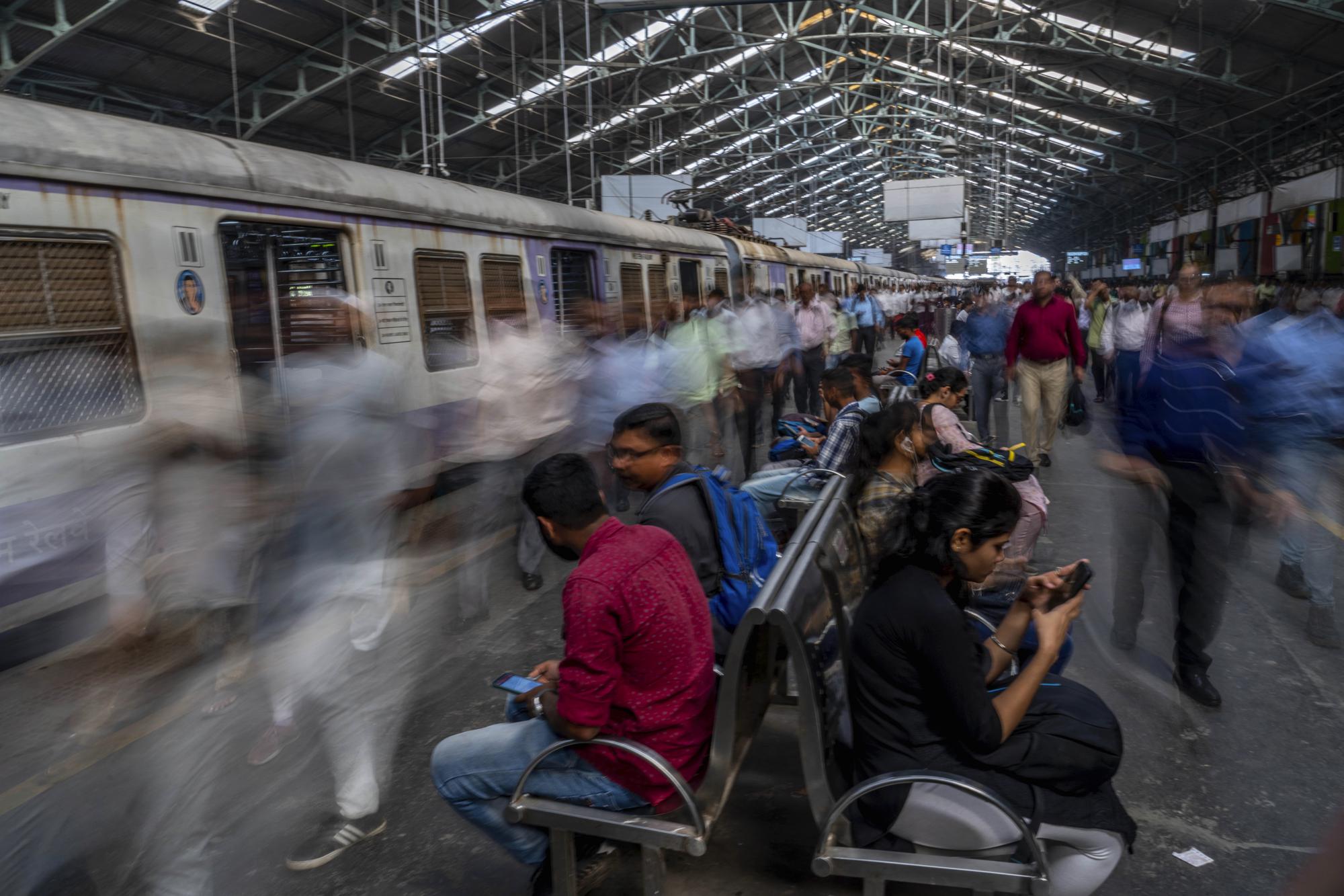 Indian commuters get off trains at the Church Gate railway station in Mumbai, India, Monday, Nov. 14, 2022. The world's population is projected to hit an estimated 8 billion people on Tuesday, Nov. 15, according to a United Nations projection. (AP Photo/Rafiq Maqbool)