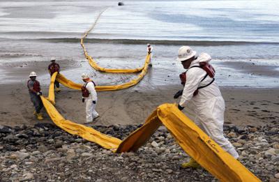ARCHIVO - Trabajadores preparan una bolla de contención en Refugio State Beach, al norte de Goleta, California, el 21 de mayo de 2015, dos días después de un derrame de crudo en un oleoducto, incidente que contaminó playas y mató y ensució a cientos de aves y mamíferos marinos en la zona. (AP Foto/Jae C. Hong, Archivo)