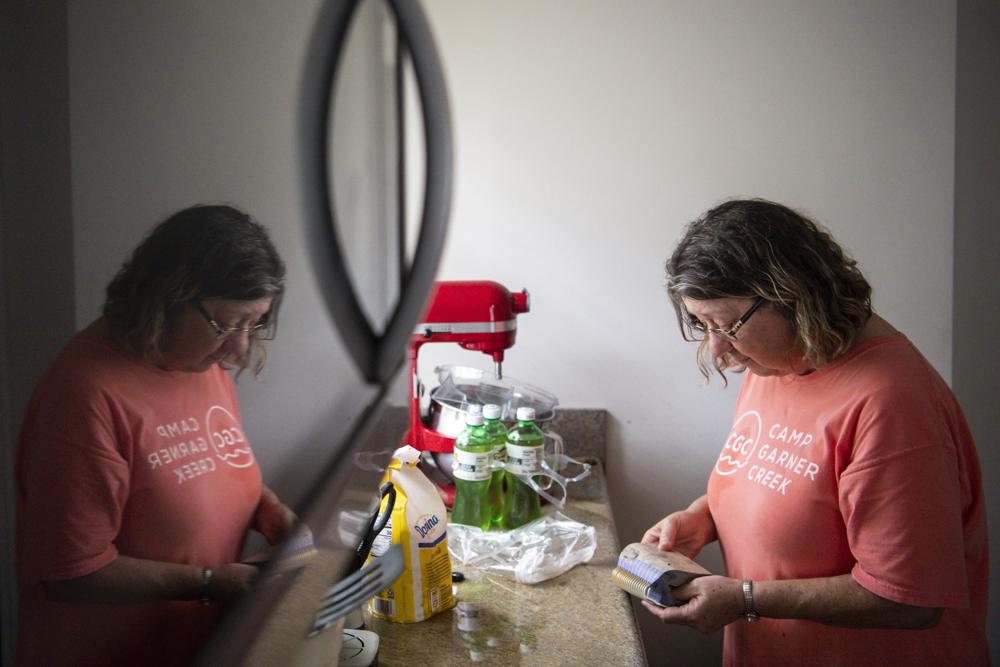 Joy Rhodes looks through a ruined calendar in her kitchen after her home flooded following heavy rainfall Saturday, Aug. 21, 2021, in Dickson, Tenn. Heavy flooding in several Middle Tennessee counties on Saturday prompted water rescues, road closures, and communications disruptions, with several people reported missing. Flash flood warnings were in effect for Dickson, Houston and Montgomery and Stewart counties on Saturday evening. (Josie Norris/The Tennessean via AP)