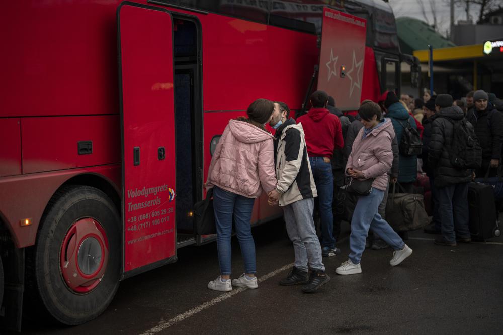 Một cặp đôi hôn tạm biệt trước khi người phụ nữ lên xe buýt rời Kyiv, Ukraine, Thứ Năm, ngày 24 tháng 2 năm 2022. (Ảnh AP / Emilio Morenatti)